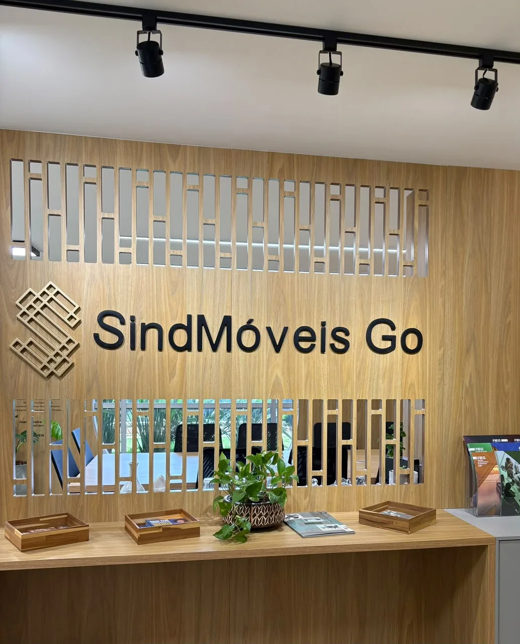 Recepção da sede do SindMóveis-GO, com a logo em painel de madeira